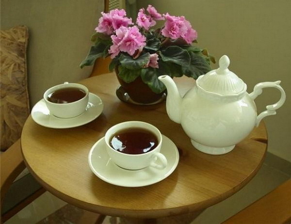 Mesa arrumada com caneca e planta ao lado de luz suave